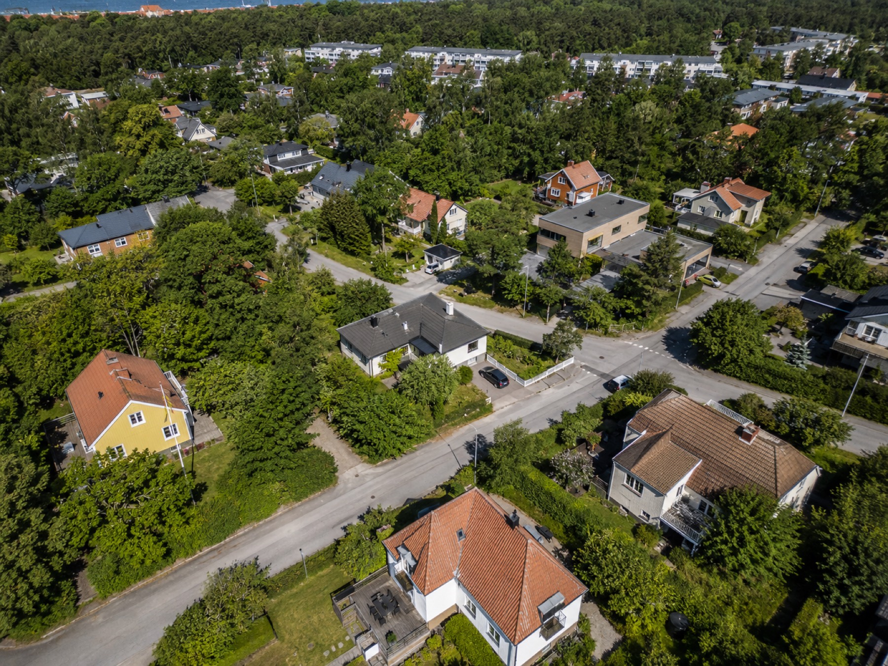 Dronefoto av boligområde ved fjorden i sommerlys