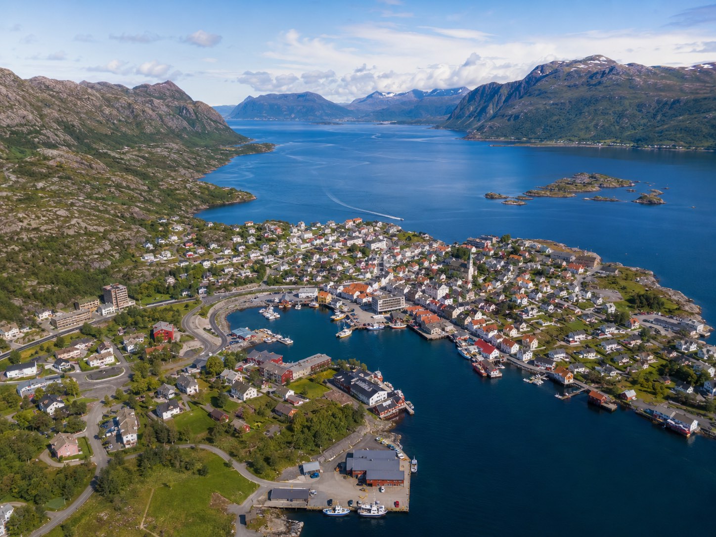 Luftfoto av en norsk kystby ved fjorden i sommerlys